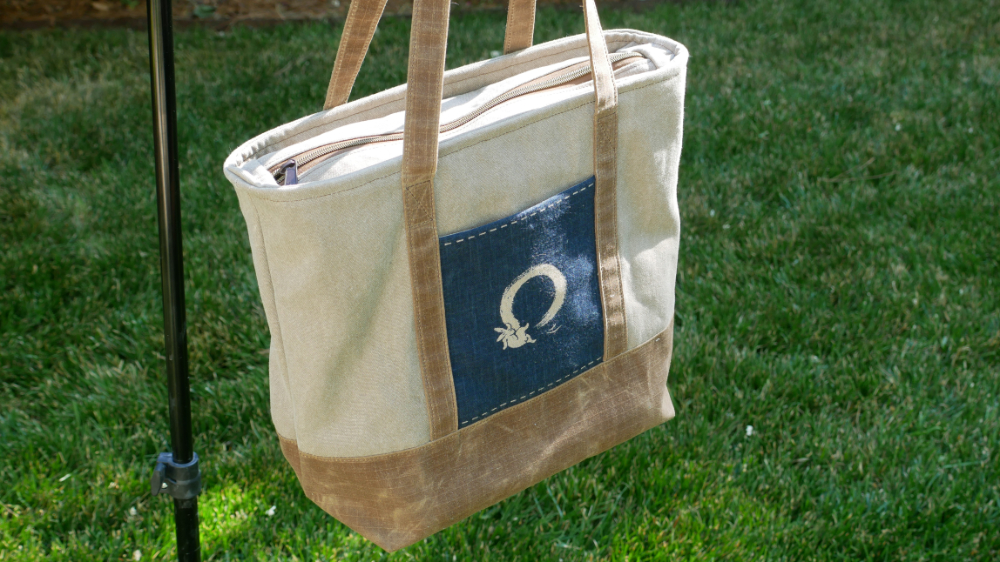 Enso Rabbit Tote Bag in natural cotton canvas with tan waxed cotton trim and a navy Japanese print front pocket showing a brushed enso circle and rabbit